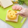 Cartoon animal sandwich cutter set with bento and holiday-themed molds for fun, shaped sandwiches.