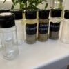 Set of 10 plastic pepper shakers, each with a 100ml capacity, featuring a perforated lid for easy dispensing.