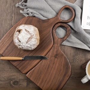 2-piece walnut chopping board set made from solid wood with form-fitting design and hanging hole