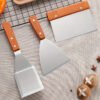 Premium stainless steel spatula set with wooden handles for cooking and flipping.