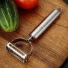 Stainless steel 2-in-1 peeler and shredder tool for peeling and shredding fruits, vegetables, and more.