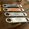 Custom metal beverage opener with personalized name engraving.