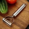 Stainless steel 2-in-1 peeler and shredder tool for peeling and shredding fruits, vegetables, and more.
